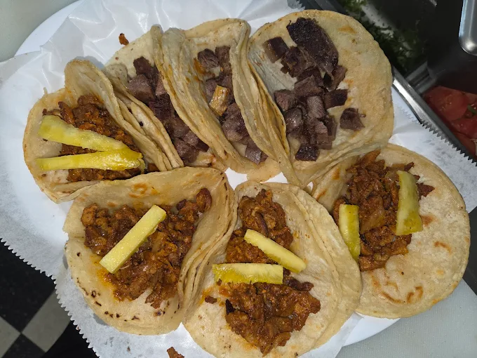 Plate of al pastor and carne asada street tacos with pineapple